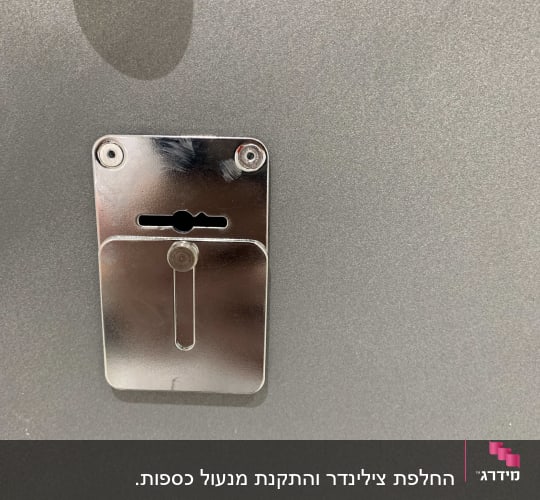 מנעול מתכת עם חריץ מפתח על דלת אפורה
